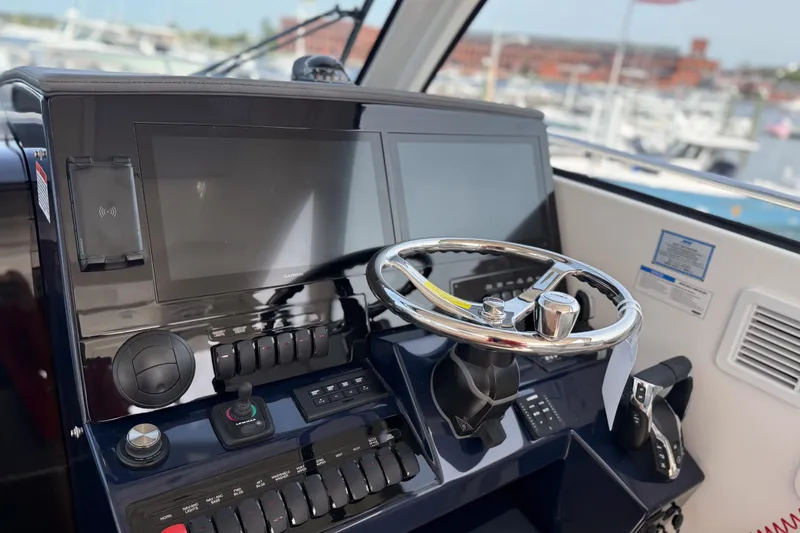 Slide: The Image of Helm of 2026 Pursuit OS 325 Offshore boat with modern controls and dual screens. - 10