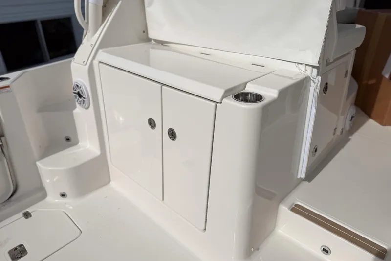 Slide: The Image of 2026 Pursuit OS 325 Offshore boat interior with storage compartment and cup holder. - 6