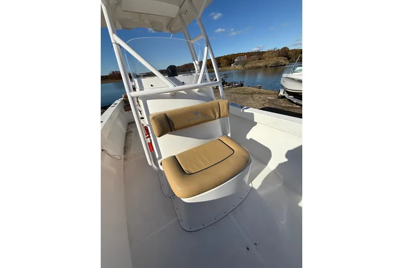 Slide: The Image of 2020 Bristol Harbor Vanquish boat interior with tan seating, docked by a scenic lake. - 10