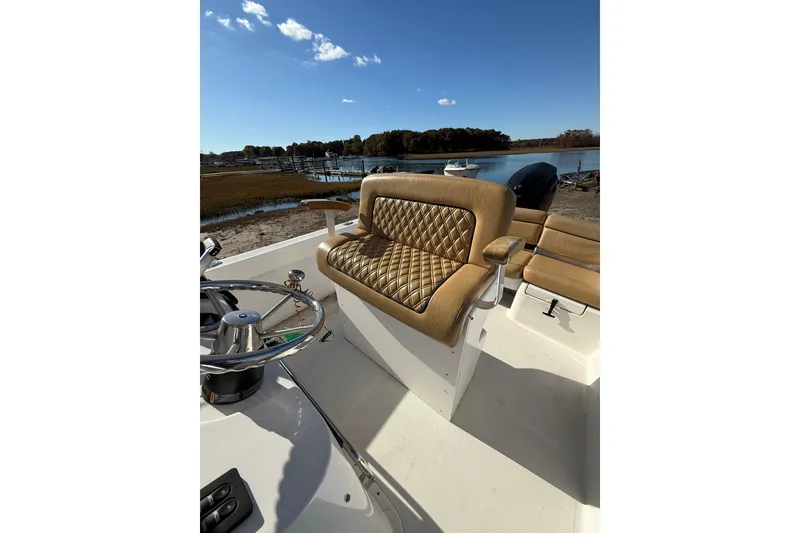 Slide: The Image of 2020 Bristol Harbor Vanquish boat interior with tan quilted seating and steering wheel. - 13