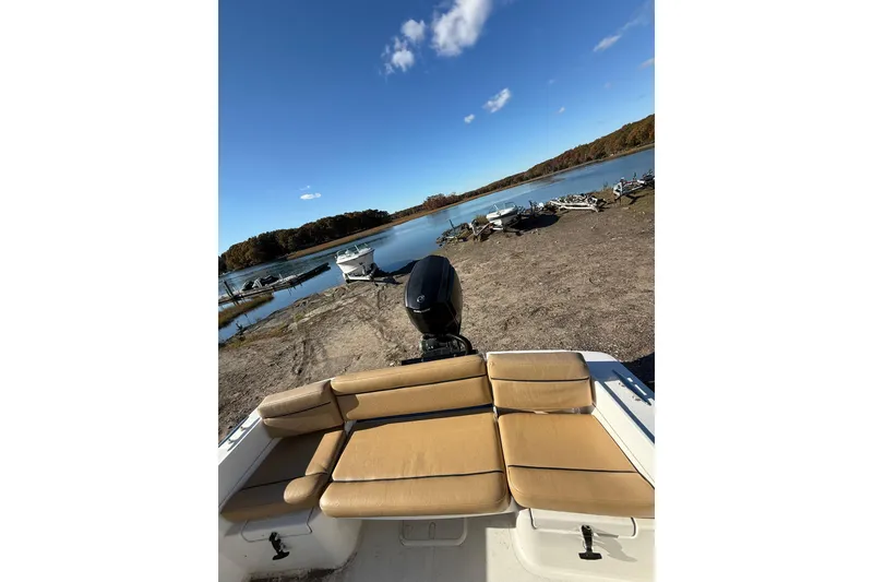 Slide: The Image of 2020 Bristol Harbor Vanquish boat with tan seating, parked by a serene lakeside. - 17