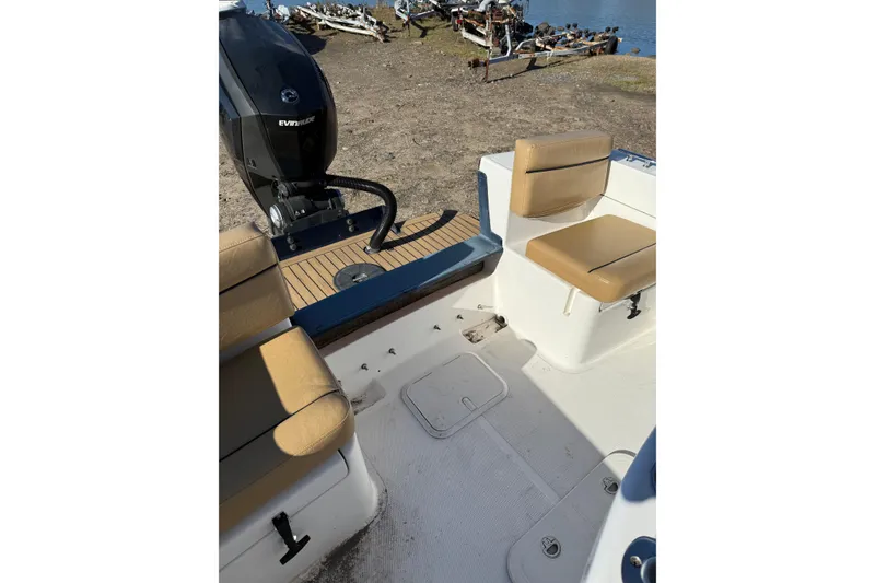 Slide: The Image of 2020 Bristol Harbor Vanquish boat interior with tan seating and Evinrude outboard motor. - 18