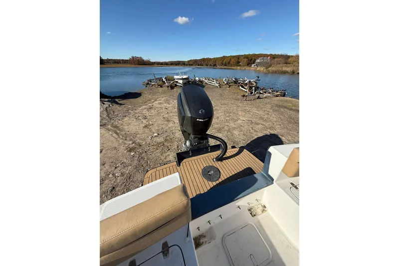 Slide: The Image of Bristol Harbor Vanquish 2020 boat with outboard motor by a serene lakeside. - 6