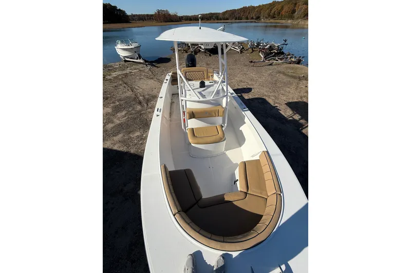 Slide: The Image of 2020 Bristol Harbor Vanquish boat with tan seating, docked by a serene lake. - 8