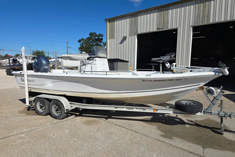 Slide: The Image of 2006 Sea Quest 2100 Probay boat on trailer, parked outside a metal building. - 5