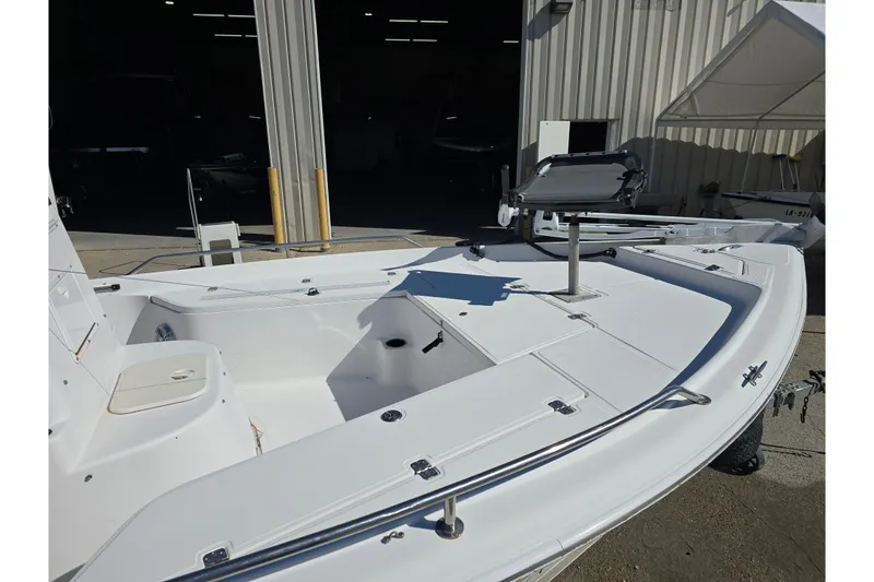 Slide: The Image of 2006 Sea Quest 2100 Probay boat, white deck, parked outside a warehouse. - 6
