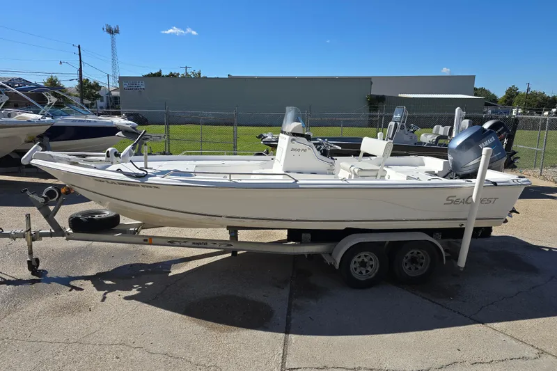 Slide: The Image of 2006 Sea Quest 2100 Probay boat on trailer, parked outdoors under clear blue sky. - 9