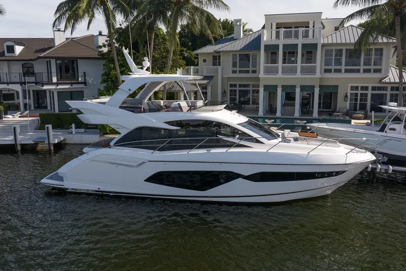 The Image of 2020 Sunseeker Manhattan 52 yacht docked by luxury waterfront home. - 1