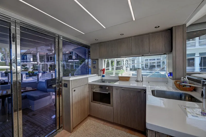 Slide: The Image of Modern kitchen interior on a 2020 Sunseeker Manhattan 52 yacht, featuring sleek cabinetry and appliances. - 17