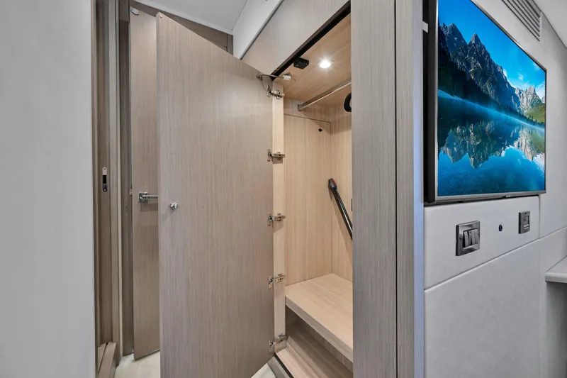 Slide: The Image of Interior of 2020 Sunseeker Manhattan 52 yacht with open storage and wall-mounted TV. - 43