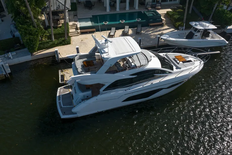 Slide: The Image of 2020 Sunseeker Manhattan 52 yacht docked by waterfront property. - 6