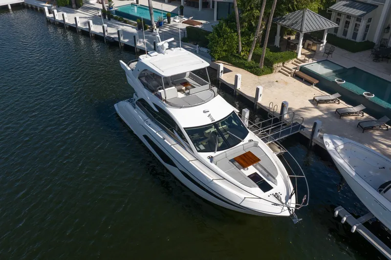 Slide: The Image of 2020 Sunseeker Manhattan 52 yacht docked by luxury waterfront property. - 7