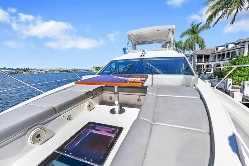 Slide: The Image of 2020 Sunseeker Manhattan 52 yacht deck with seating, table, and waterfront view. - 9