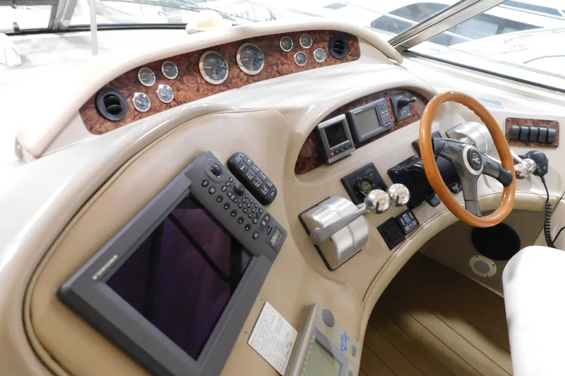 Slide: The Image of 1998 Sea Ray 540 Sundancer helm with wood accents and modern navigation equipment. - 10