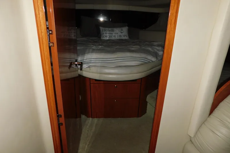 Slide: The Image of 1998 Sea Ray 540 Sundancer cabin interior with bed and wooden cabinetry. - 24