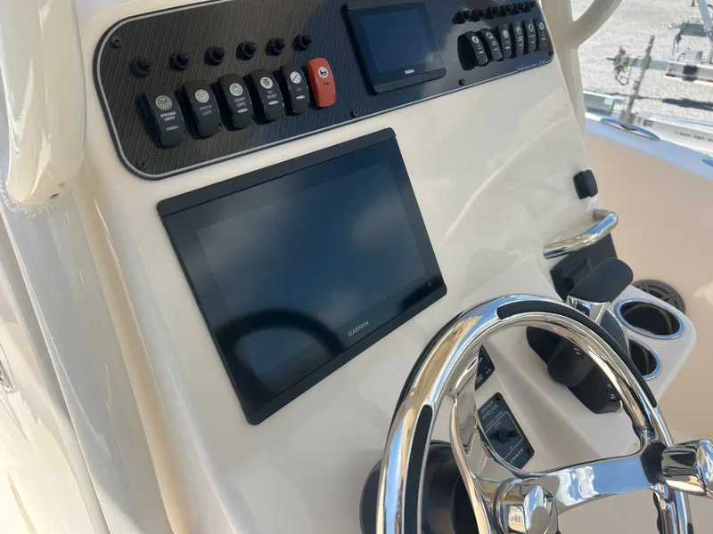 Slide: The Image of The image shows the helm of a Grady-White Fisherman 236 with modern instruments and a shiny steering wheel. - 13
