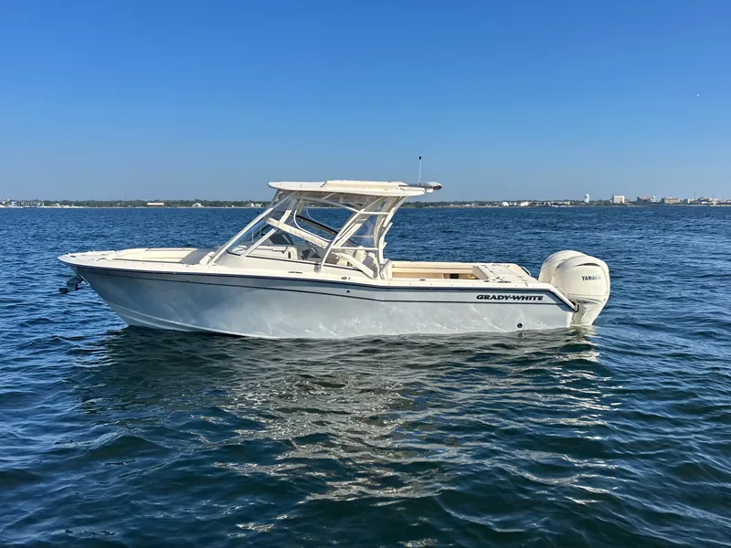 Slide: The Image of A 2026 Grady-White Freedom 275 boat on calm water under a clear sky. - 1