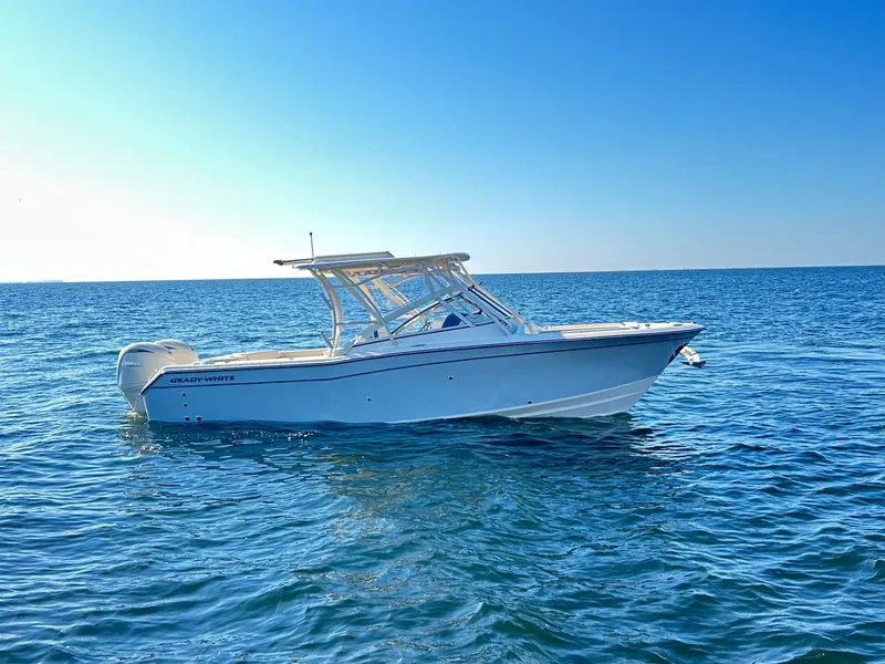 Slide: The Image of A 2026 Grady-White Freedom 275 boat floats on calm, blue water under a clear sky. - 5
