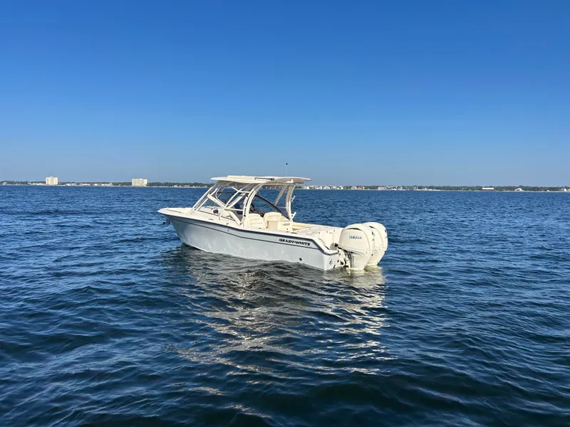 Slide: The Image of A 2026 Grady-White Freedom 275 boat floats on calm water under a clear sky. - 3