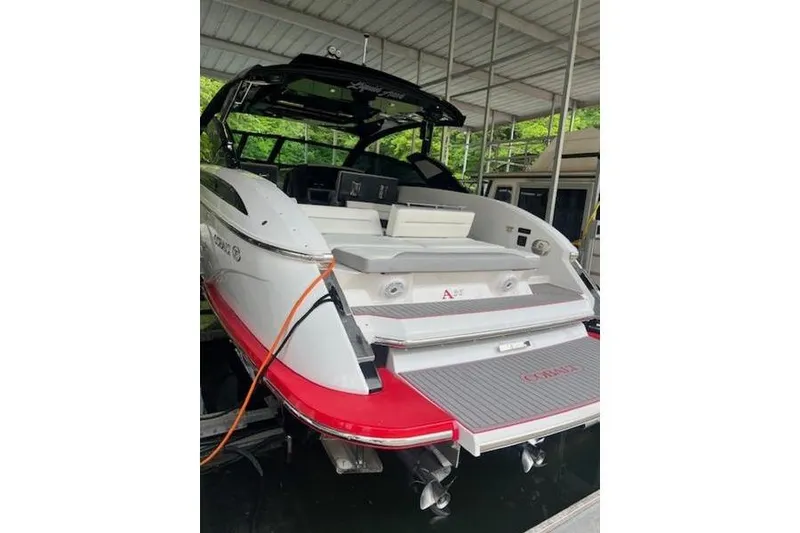 Slide: The Image of 2021 Cobalt A36BR boat with sleek design, docked under a covered marina. - 11