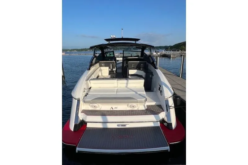 Slide: The Image of 2021 Cobalt A36BR boat docked, rear view showing spacious seating and sleek design. - 9