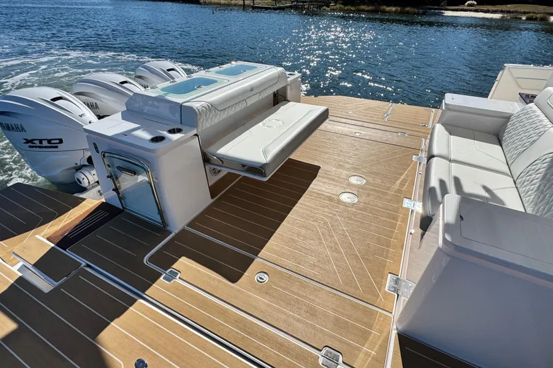 Slide: The Image of 2025 Regal 43 SAV boat deck with Yamaha XTO engines, featuring luxurious seating and teak flooring. - 13