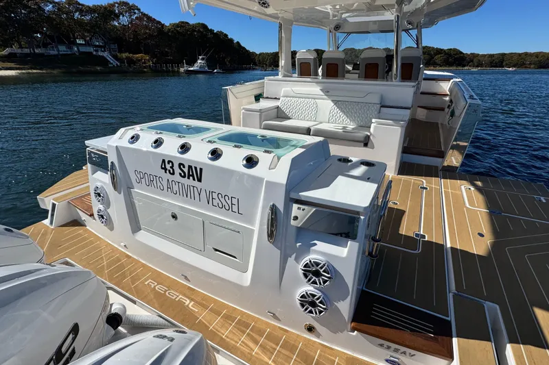Slide: The Image of 2025 Regal 43 SAV sports activity vessel on water, showcasing luxurious deck and seating. - 14
