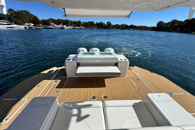 Slide: The Image of 2025 Regal 43 SAV luxury yacht on serene water, featuring spacious deck and seating. - 20