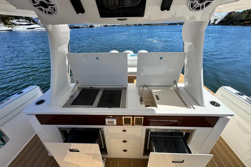 Slide: The Image of Outdoor kitchen on 2025 Regal 43 SAV yacht with grill and sink by the water. - 22