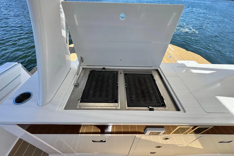Slide: The Image of Outdoor grill on 2025 Regal 43 SAV yacht, open lid, overlooking water. - 23