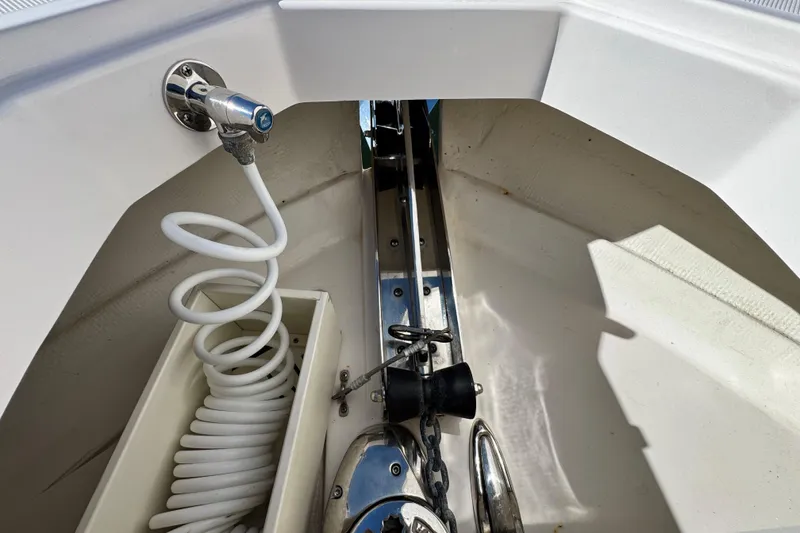 Slide: The Image of Anchor compartment of 2025 Regal 43 SAV boat with coiled hose and fittings. - 34