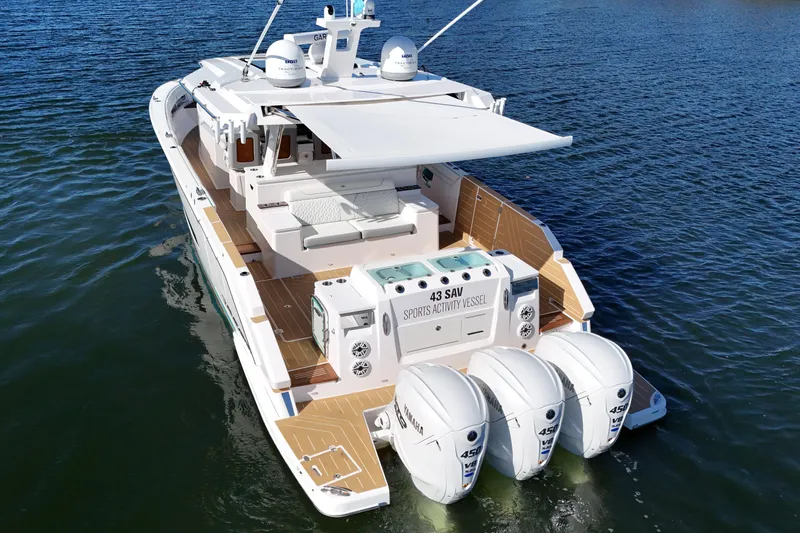 Slide: The Image of 2025 Regal 43 SAV sports activity vessel with triple outboard engines on water. - 8