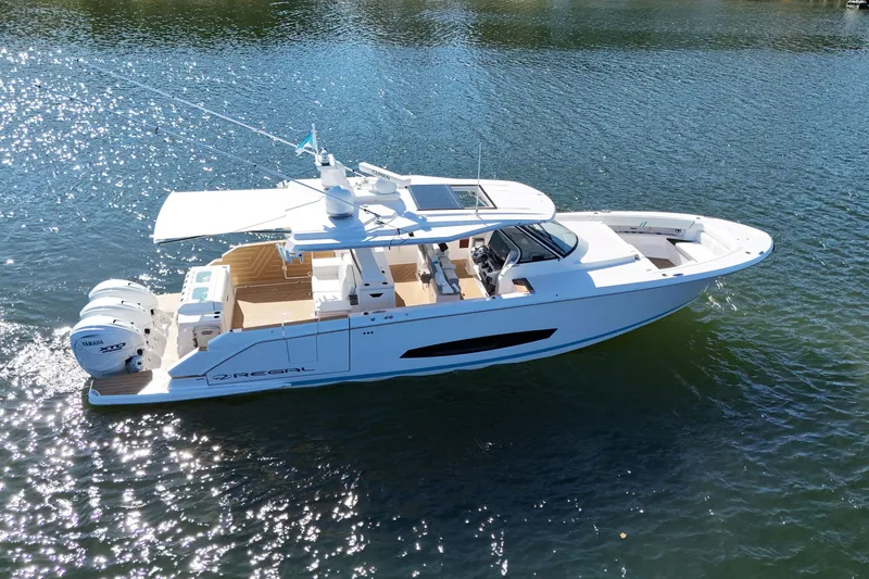 Slide: The Image of 2025 Regal 43 SAV luxury boat cruising on sparkling water. - 9