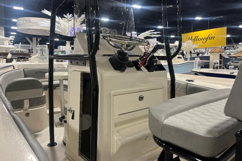 Slide: The Image of 2026 Sea Chaser 22 HFC boat interior at a boat show, featuring seating and controls. - 7