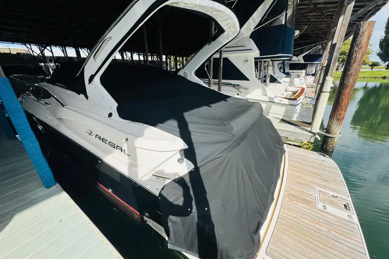 Slide: The Image of 2006 Regal 3360 Window Express boat docked under a covered marina. - 10