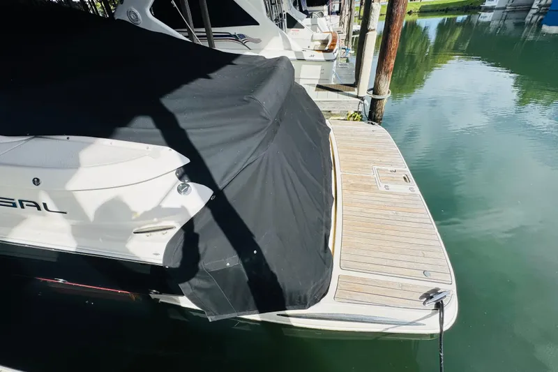 Slide: The Image of 2006 Regal 3360 Window Express boat docked with black cover, wooden deck visible. - 11