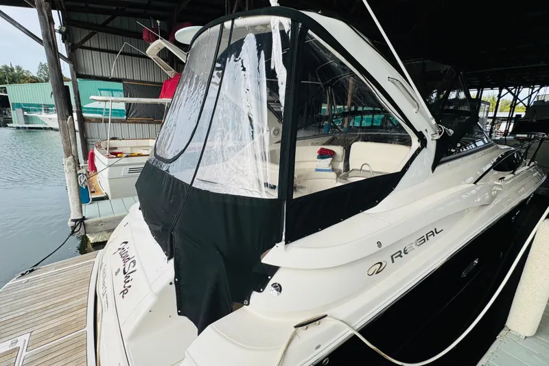 Slide: The Image of 2006 Regal 3360 Window Express boat docked in a marina, featuring a covered cockpit. - 14