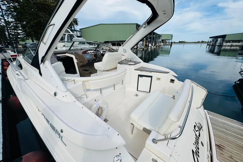 Slide: The Image of 2006 Regal 3360 Window Express boat docked at marina, featuring spacious cockpit and helm. - 26