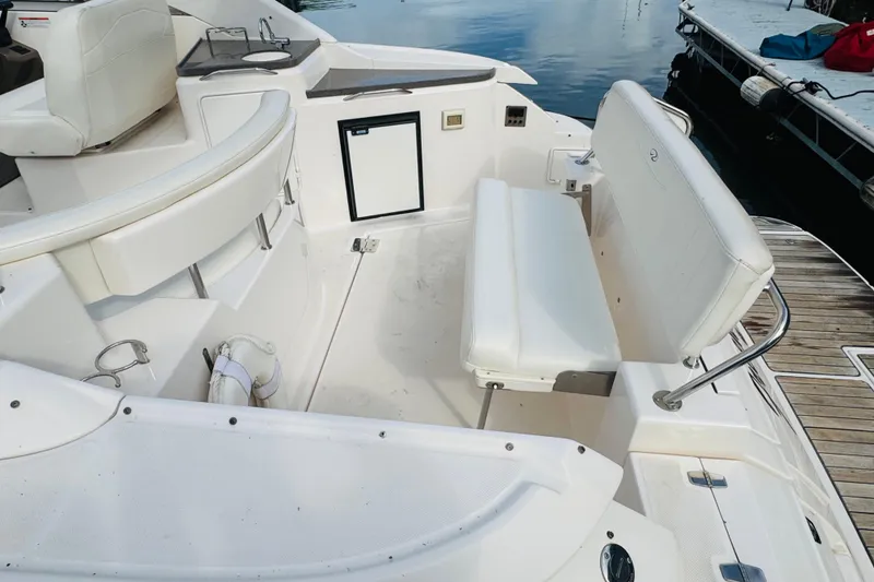 Slide: The Image of 2006 Regal 3360 Window Express boat interior with white seating and dock view. - 27