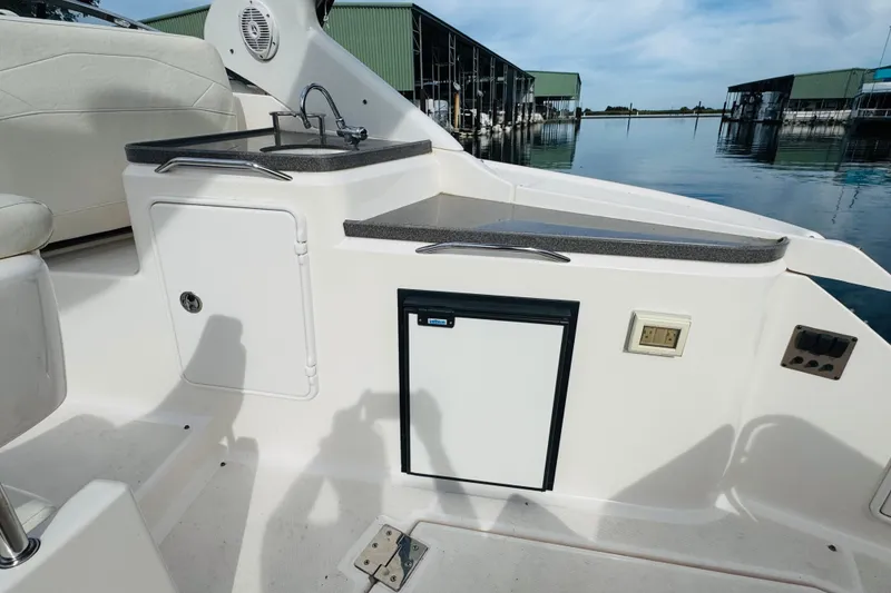 Slide: The Image of 2006 Regal 3360 Window Express boat interior with sink and storage, docked at marina. - 32