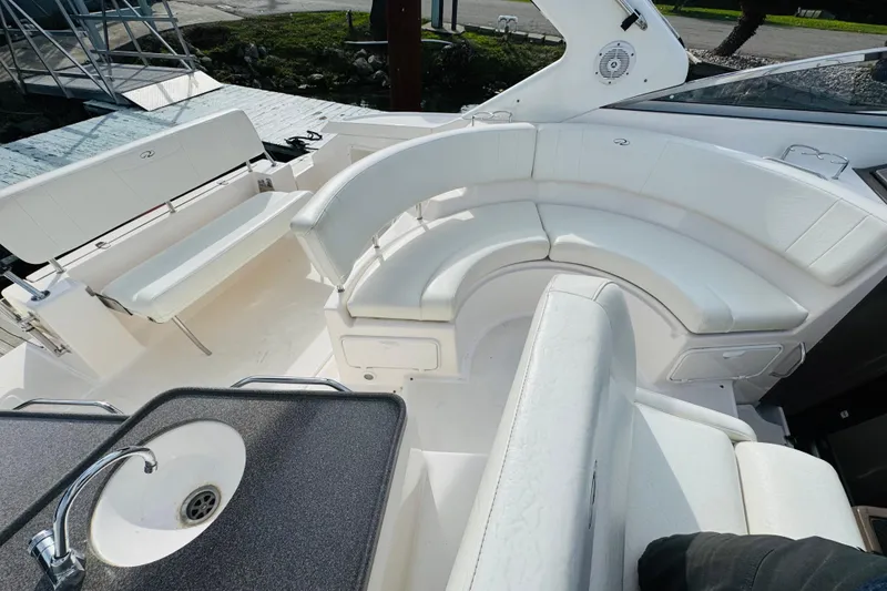 Slide: The Image of 2006 Regal 3360 Window Express boat interior with white seating and sink. - 34