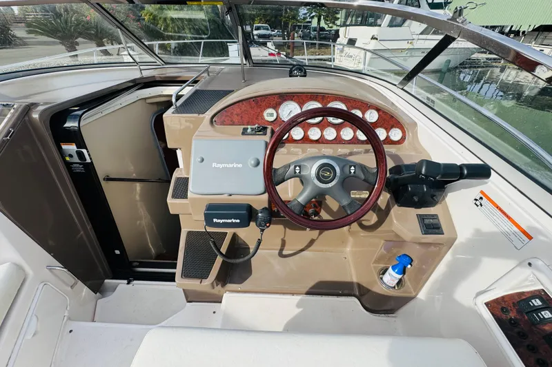 Slide: The Image of 2006 Regal 3360 Window Express boat helm with Raymarine equipment and wood-accented dashboard. - 37