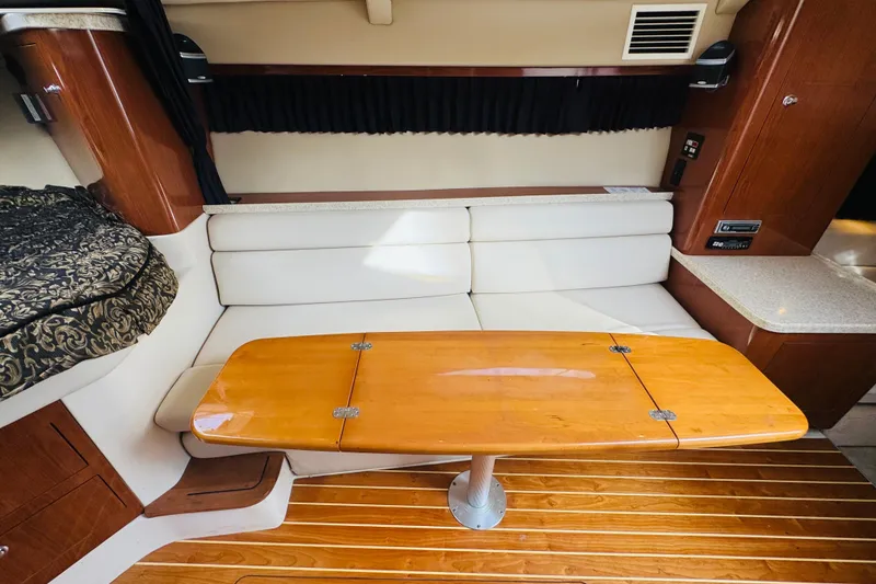 Slide: The Image of 2006 Regal 3360 Window Express interior with wooden table and white seating. - 45