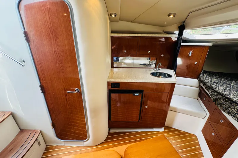 Slide: The Image of 2006 Regal 3360 Window Express interior with kitchenette, wood cabinetry, and cozy sleeping area. - 46