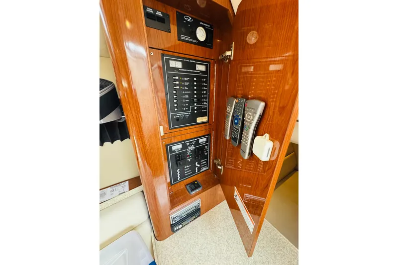 Slide: The Image of 2006 Regal 3360 Window Express control panel with remotes and wooden finish. - 59