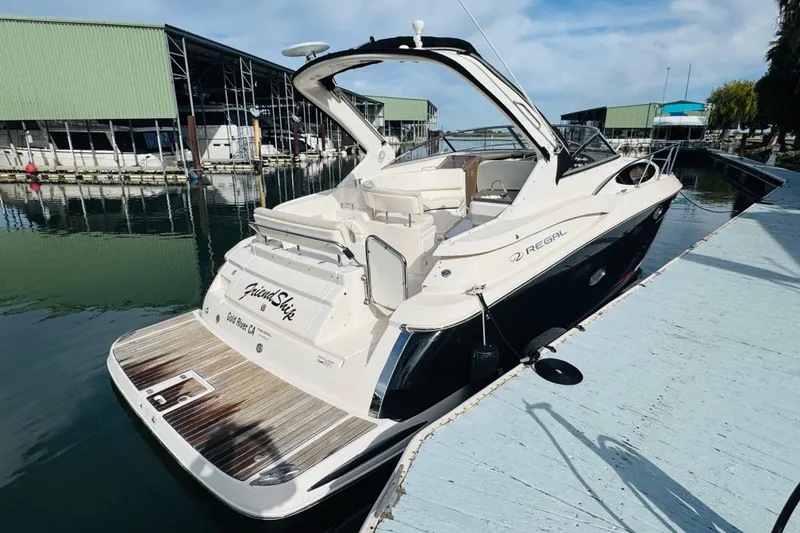 Slide: The Image of 2006 Regal 3360 Window Express boat docked at marina, featuring sleek design and spacious deck. - 6