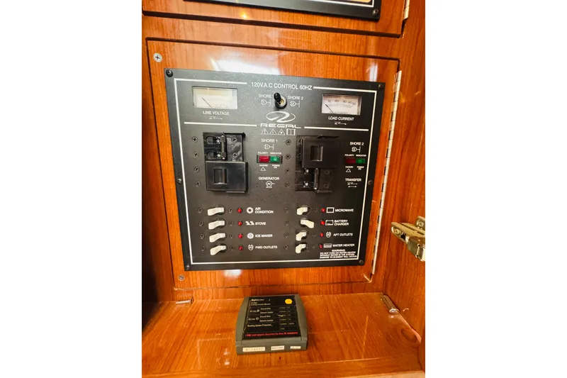 Slide: The Image of Control panel of a 2006 Regal 3360 Window Express boat, featuring electrical switches and gauges. - 61