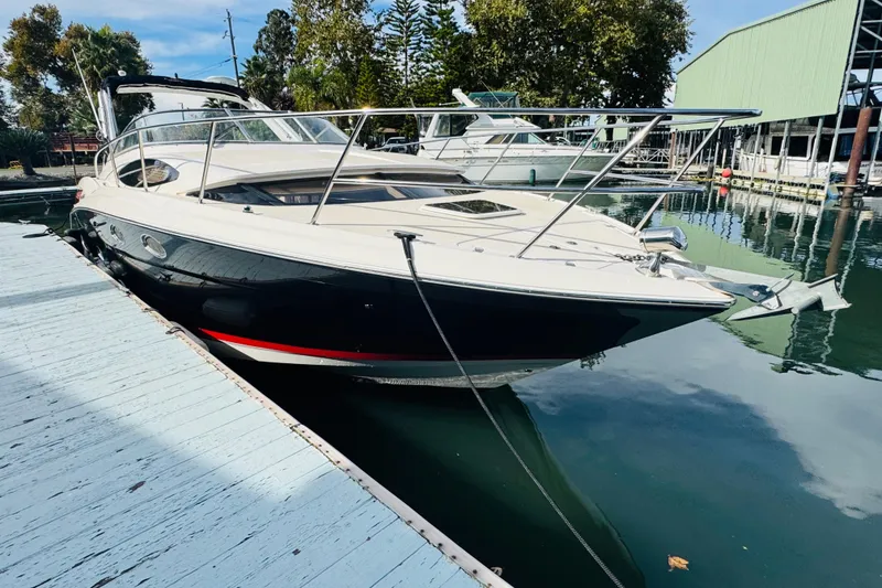 Slide: The Image of 2006 Regal 3360 Window Express boat docked at marina, reflecting on calm water. - 7