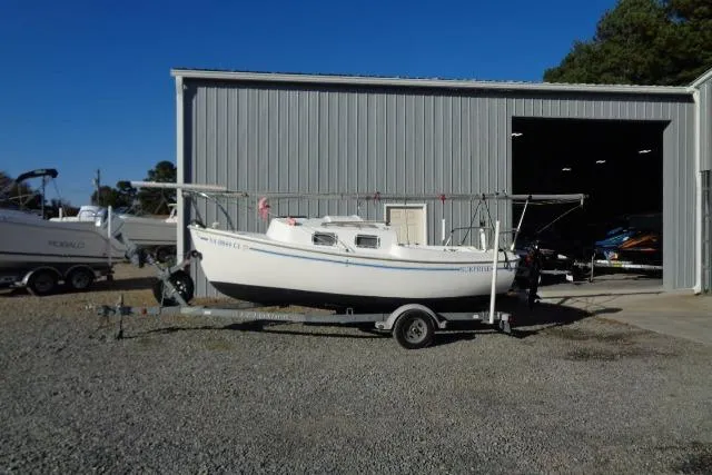 Slide: The Image of 2007 Sanibel 18 Pocket Cruiser sailboat on trailer outside metal storage building. - 5