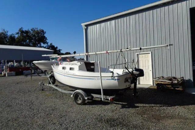 Slide: The Image of 2007 Sanibel 18 Pocket Cruiser sailboat on trailer near metal building. - 6